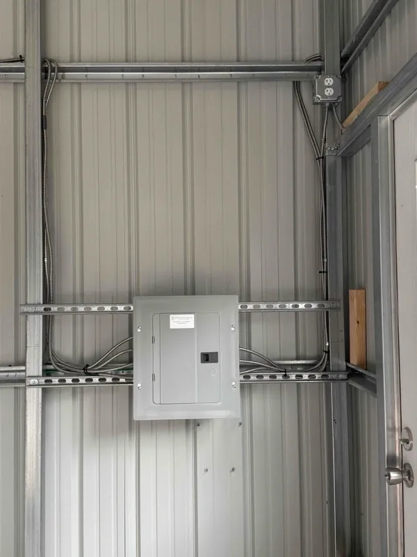 An electrical sub-panel installed in a metal shed building.