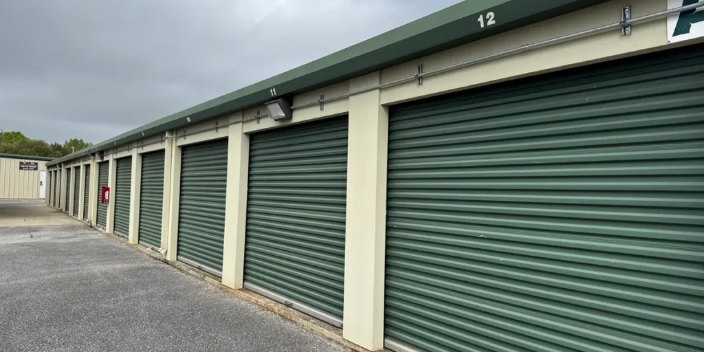 A photo of an outdoor storage building with wall pack lighting and metal electrical conduit.
