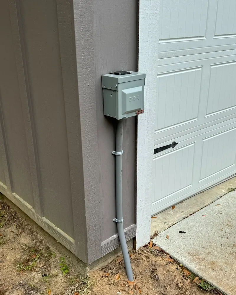 A RV receptacle in outdoor rated enclosure installed beside garage door.