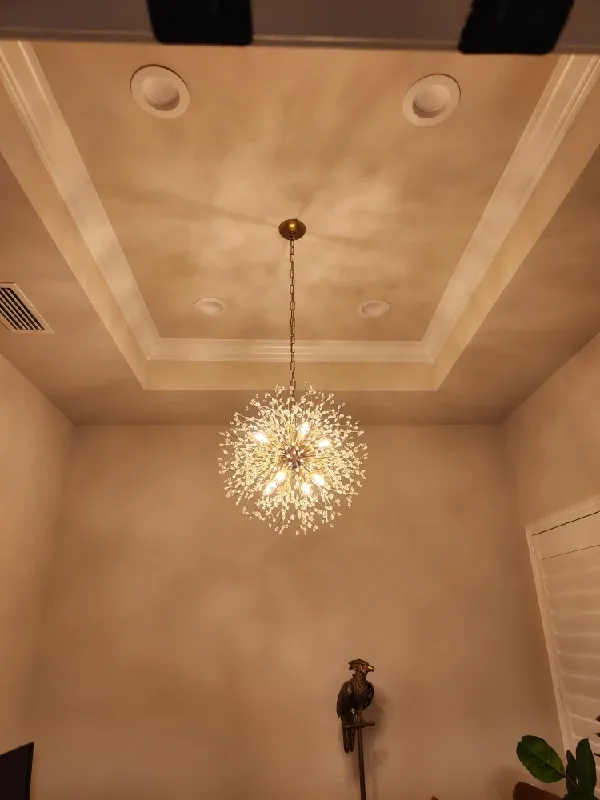 A round shaped light fixture that looks like exploding fire works.