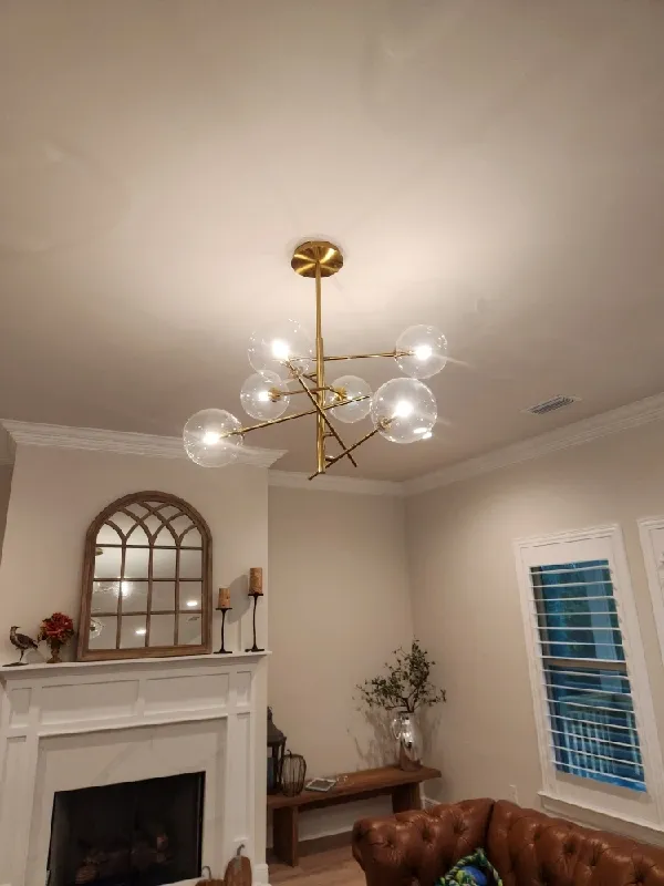 A gold multi stem, multi direction light fixture with clear globes.