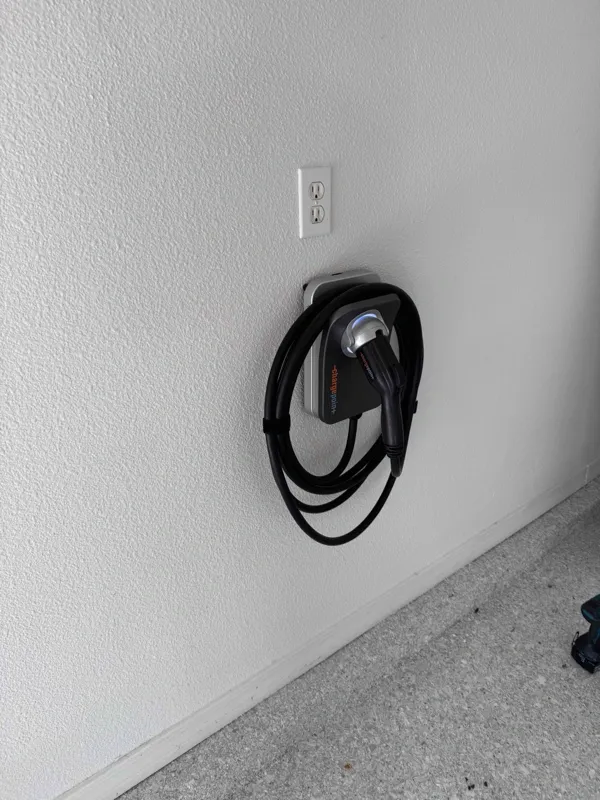 An EV charger unit mounted to the interior garage wall in a home.