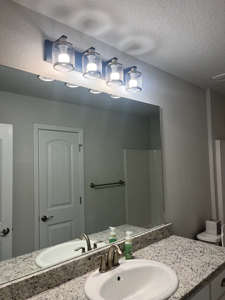 A vanity light replacement installed over the sink in a bathroom.