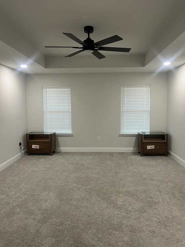 A ceiling fan and recessed light installed in a ceiling in a master bedroom.