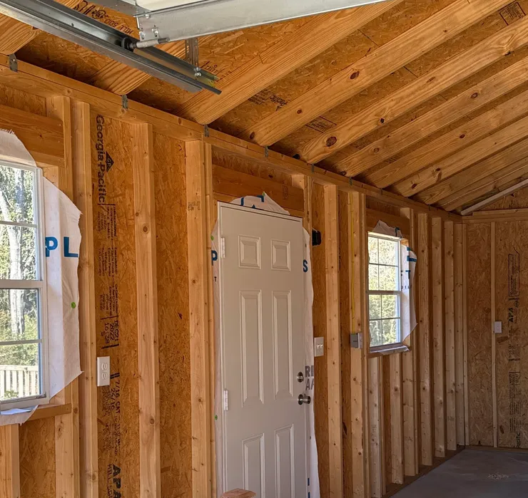 Electrical wiring, switches, and receptacles installed in a wood framed garage.