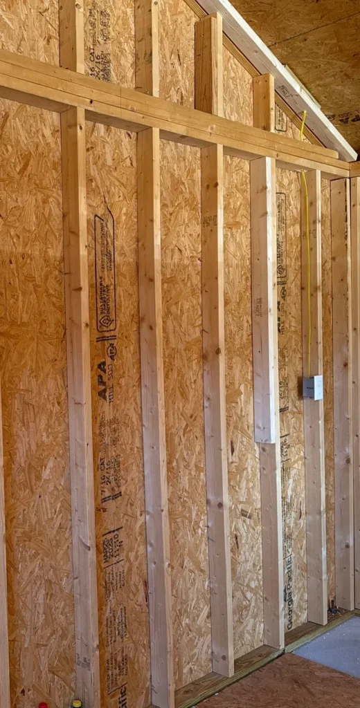 Electrical wiring and receptacle installed in a wood framed garage.