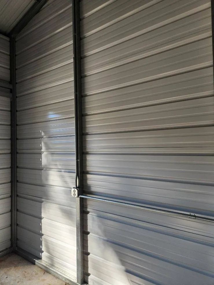 Electrical conduit and receptacle installed in a metal shed.