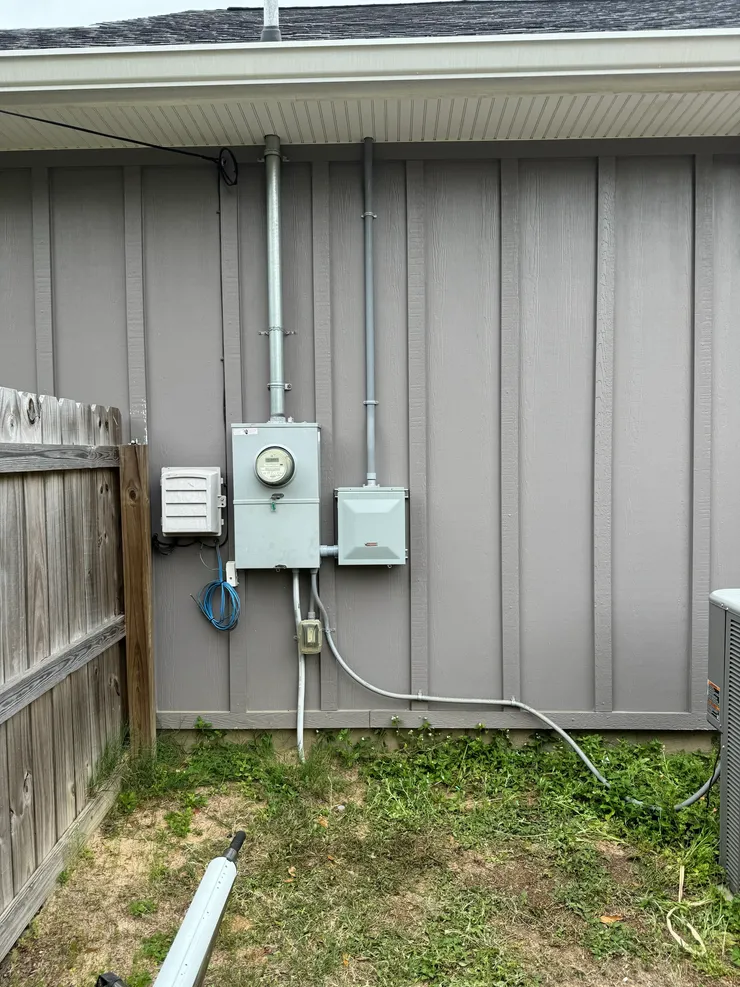 An electrical sub-panel installed beside a main electrical panel to make room for additional dedicated circuits.