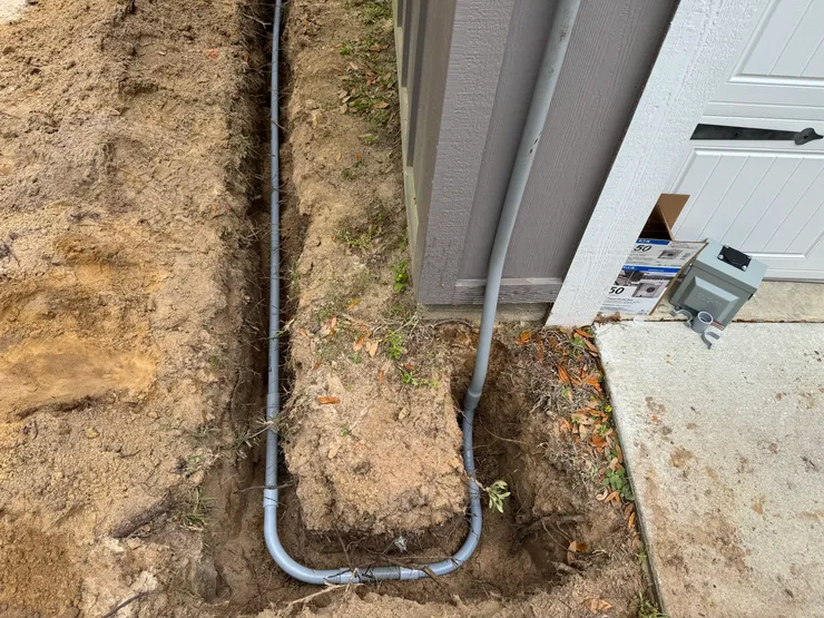 An open trench containing electrical conduit for a dedicated RV circuit.