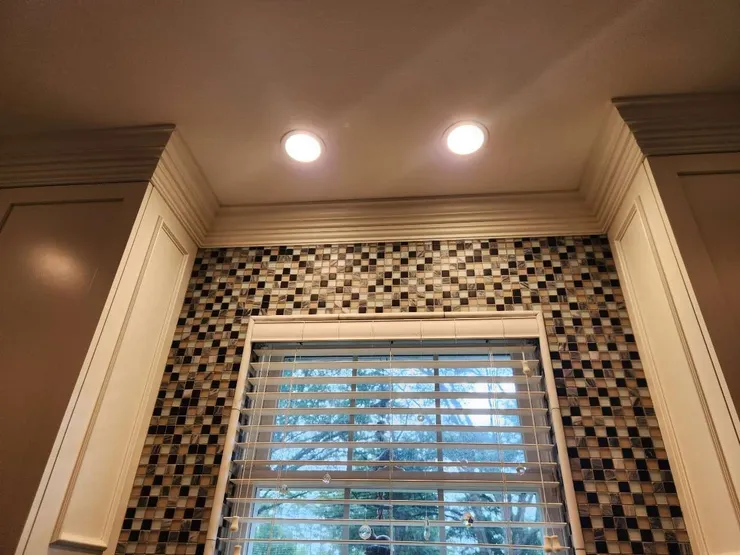 Recessed lighting installed inside above a window.