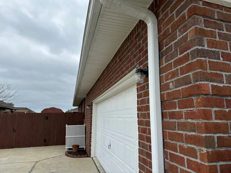 Light fixtures installed on either side of the exterior of a home garage.