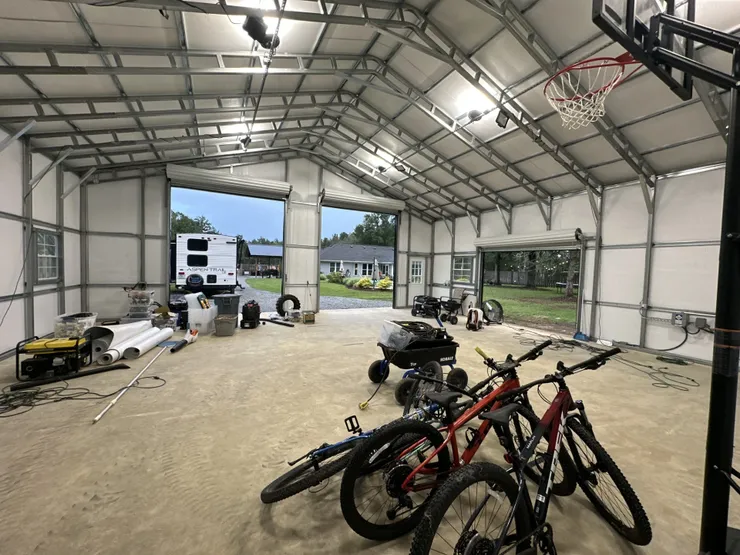 High bay light fixtures installed in the ceiling of a metal framed garage.