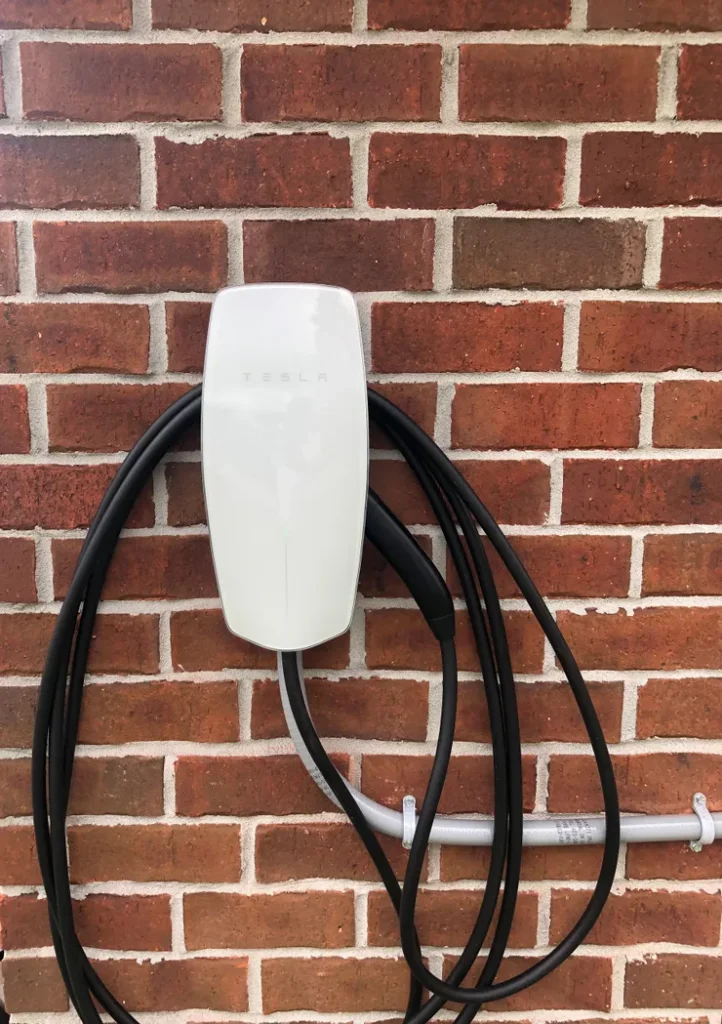 An EV charger unit mounted to a brick wall at a customer's home.