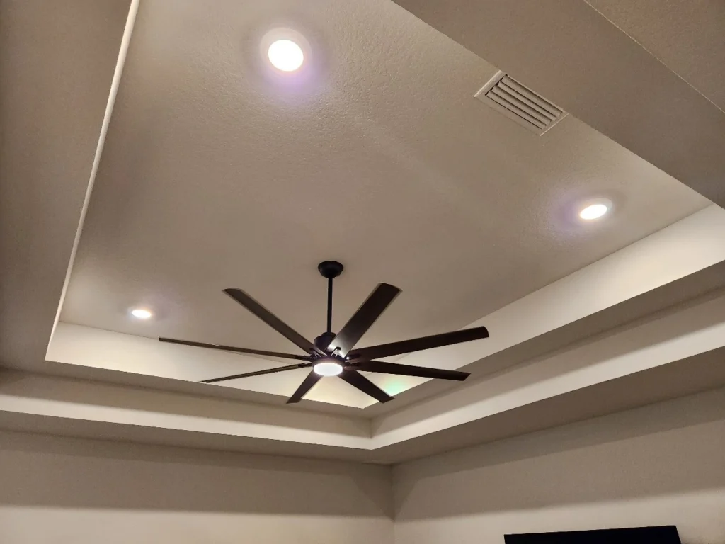 Ceiling fan and recessed lighting in a residential room.