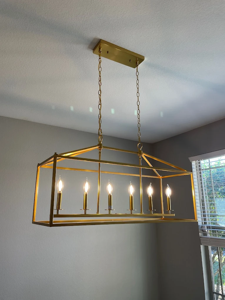 A geometric chandelier light fixture installed in the dining area of a home.