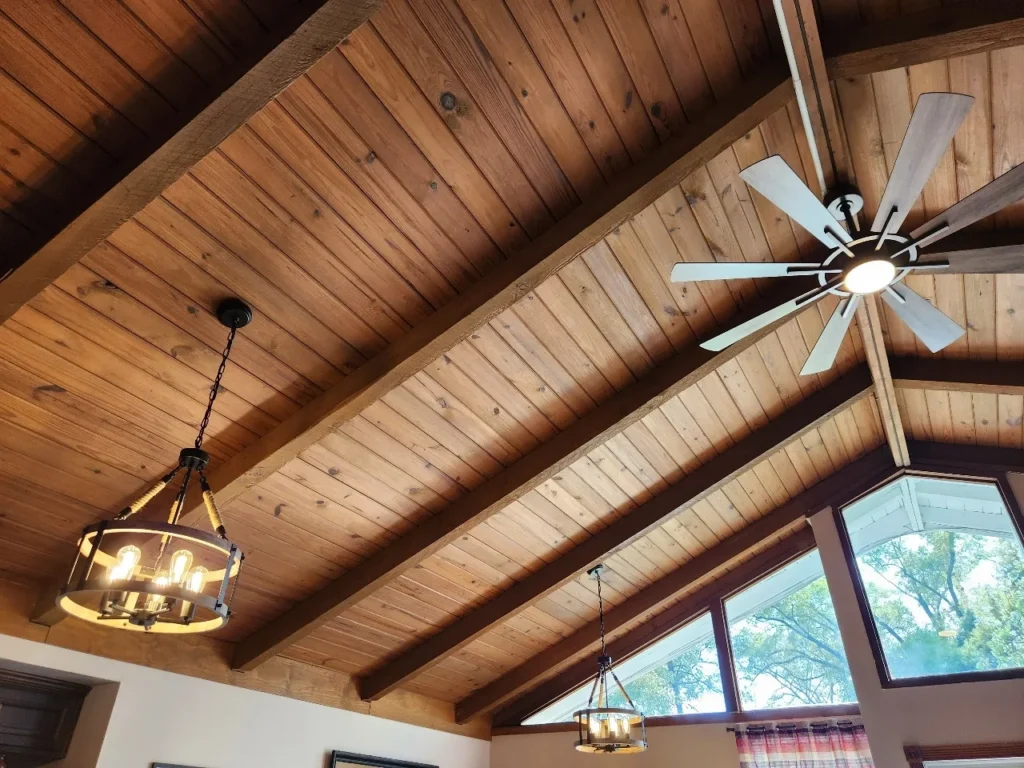 Ceiling fan and two light fixtures installed in a wood ceiling.