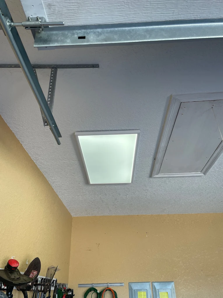 A flat panel integrated 2x4 LED light fixture installed to replace an outdated fixture in a home garage in Milton, FL.