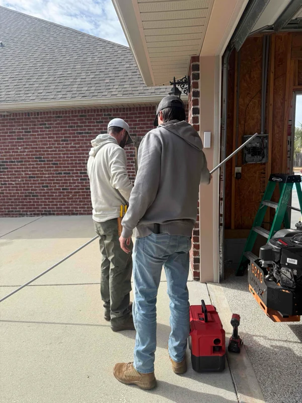 Two electricians working with electrical conduit in a separate garage at a home in Pace, FL.
