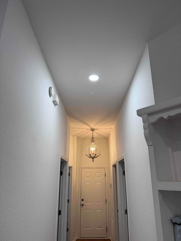 A pendant style light fixture in a hall way.