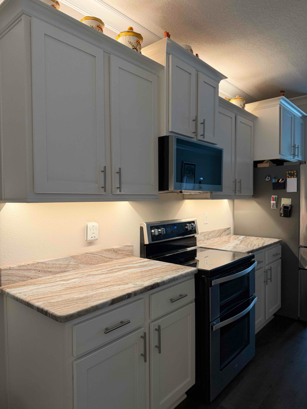 Under cabinet and above cabinet strip lighting in kitchen.